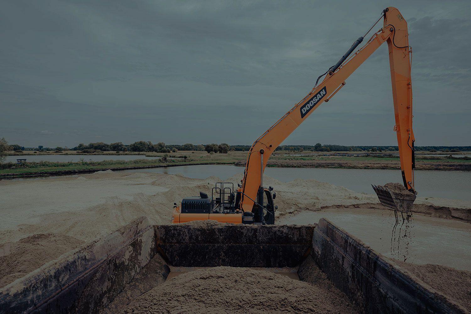 An excavator working by a river.