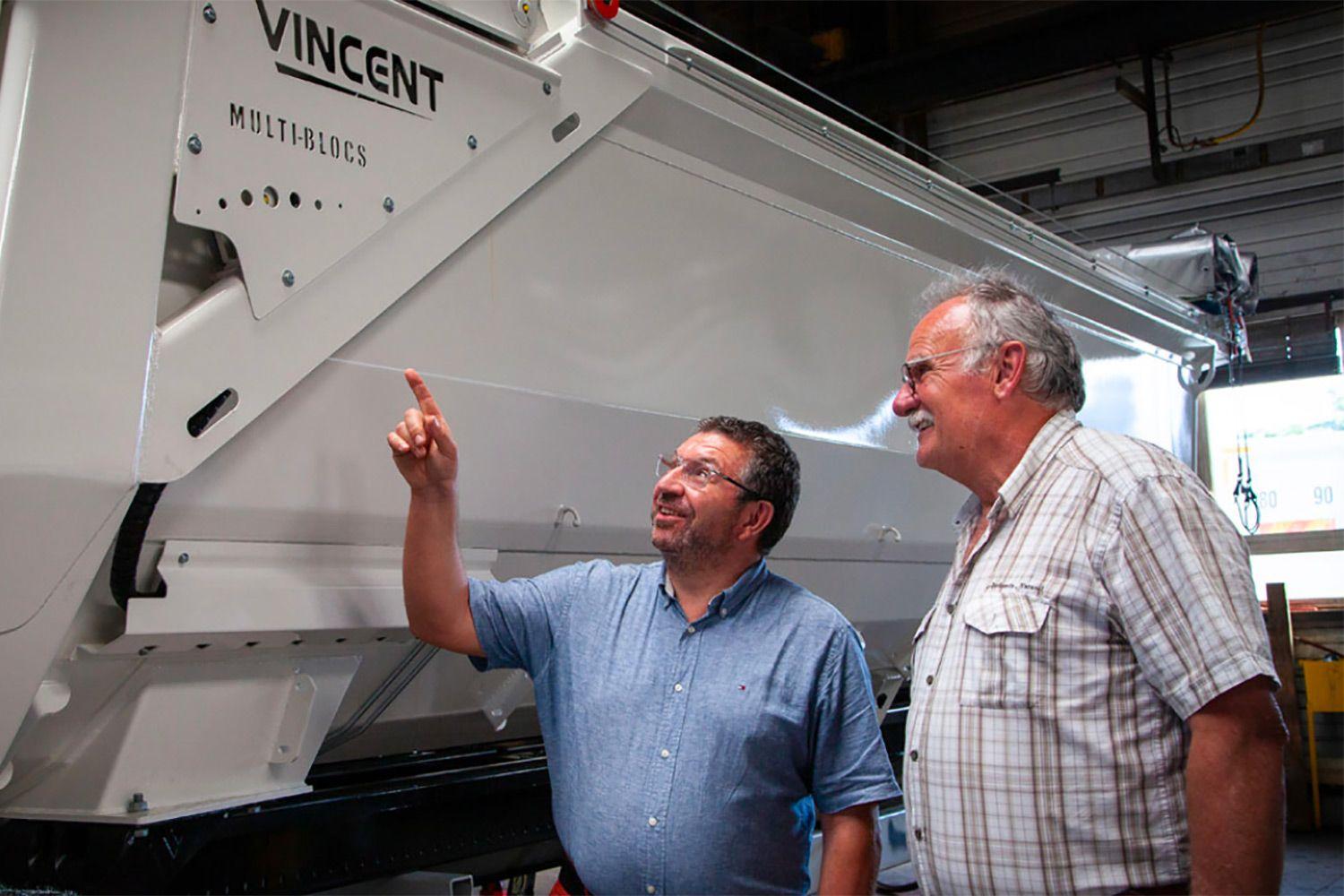 Two men in front of a Bennes Vicent truck.