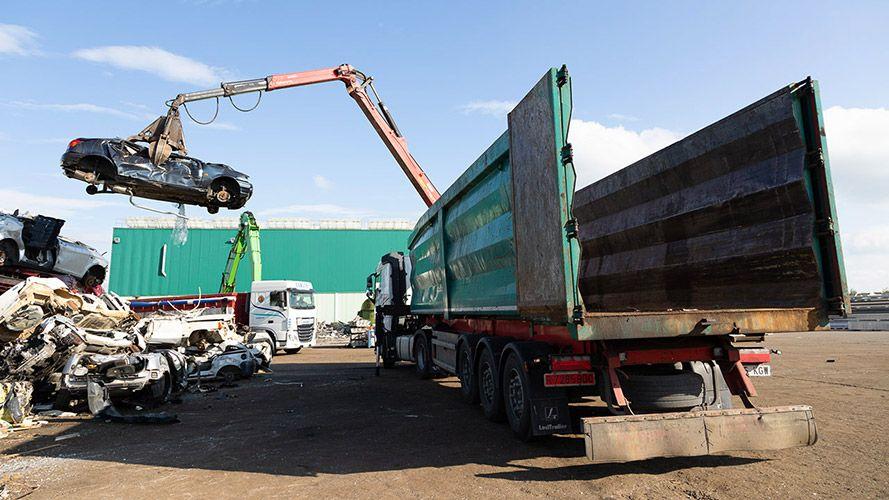 M. Torre truck with scrap car being handled.