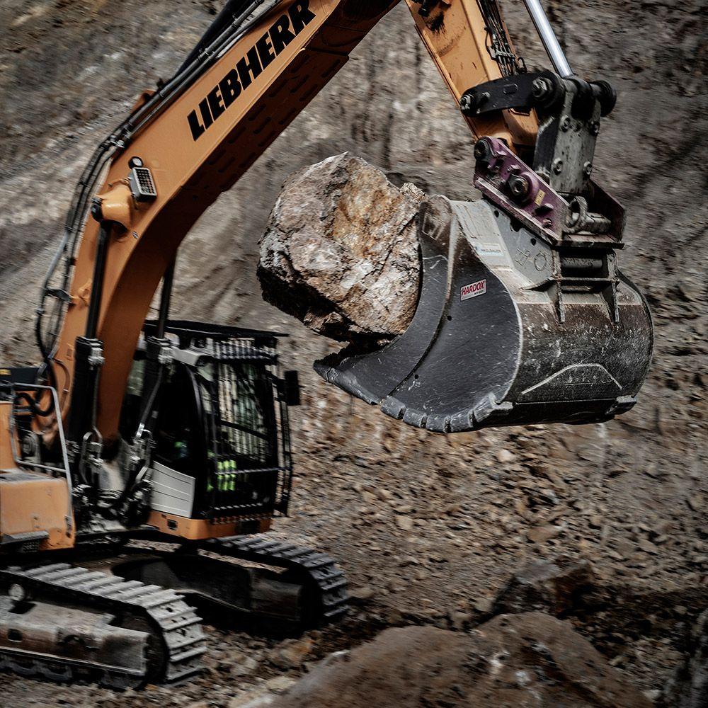 Excavator lifting a rock.